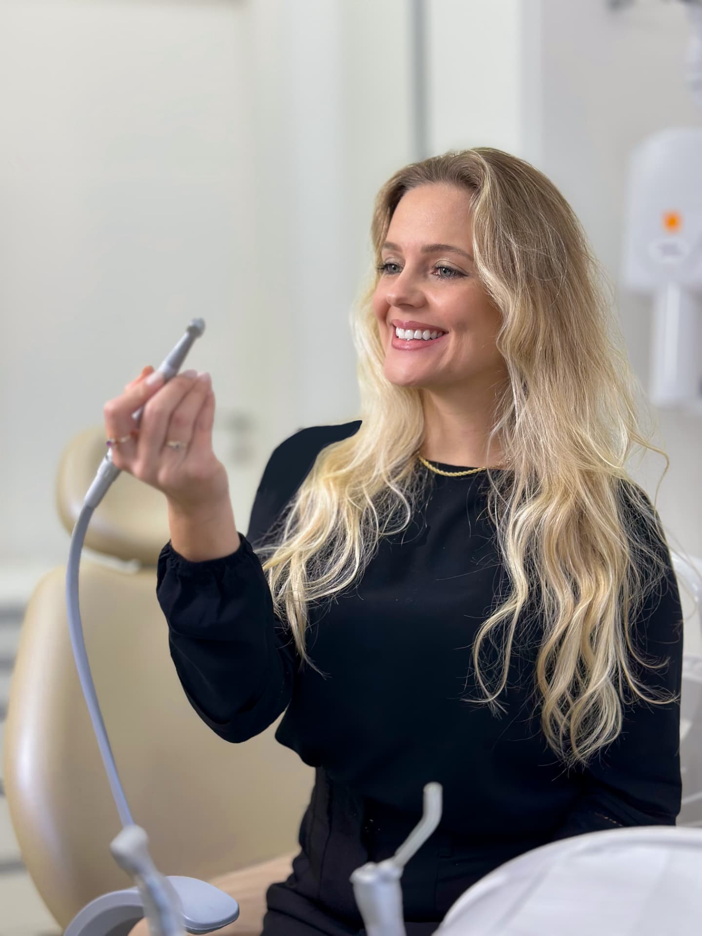 Dra. Edna Bittencurt sorrindo durante atendimento em sua clínica em Blumenau